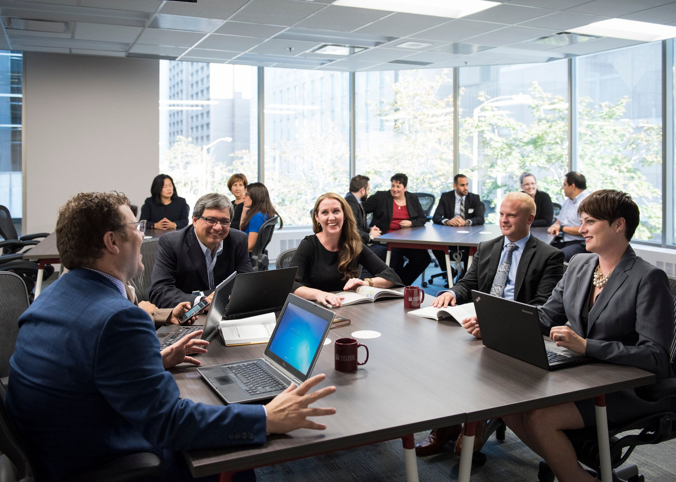 executives sitting at various table discussing
