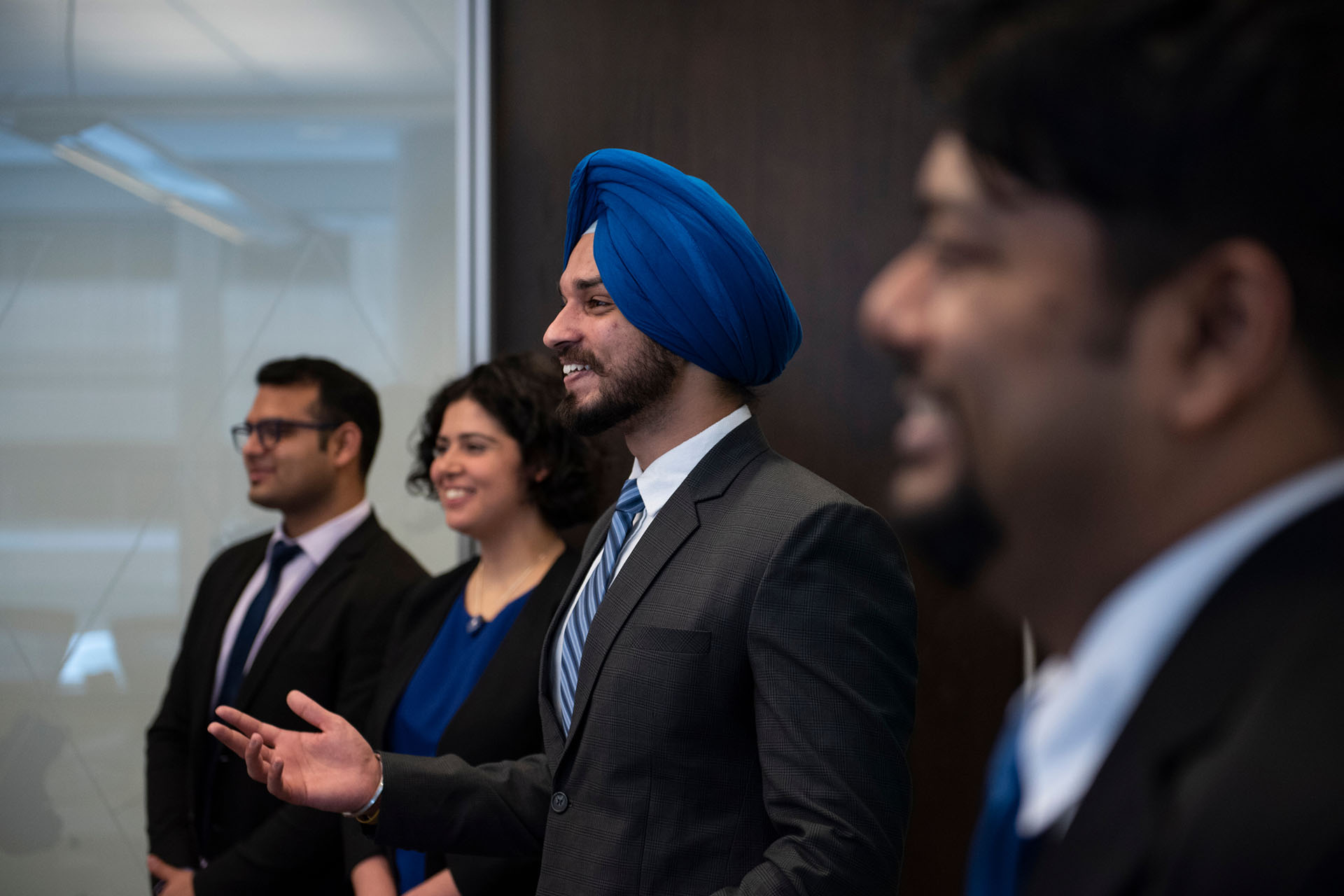 Telfer student smiling in an audience while listening to a presentation