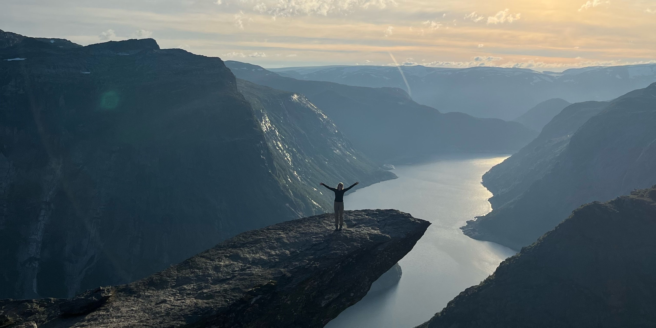 a student standing on a rock overlooking a lake